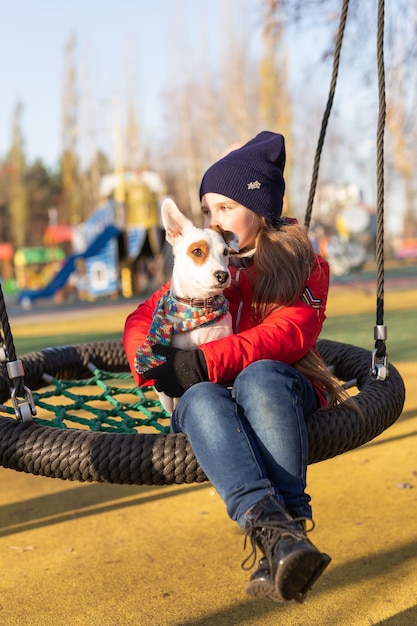 Gelukkig kind meisje met hond Portret jongen met huisdier Jack Russell Terrier buitenshuis huisdier eigenaar concept