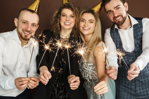 Фото Группа счастливых людей в шляпах с горящими блестками во время праздника или торжества