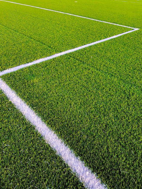 Фото Зеленая трава футбольного поля и белые направляющие линии на зеленой траве