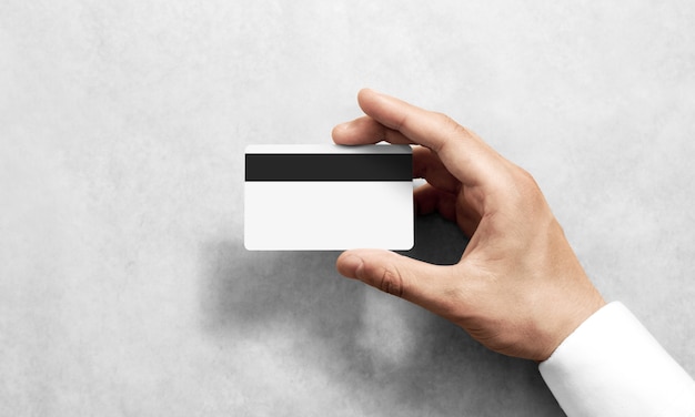 Рука макет пустой белой кредитной карты с черной магнитной полосой