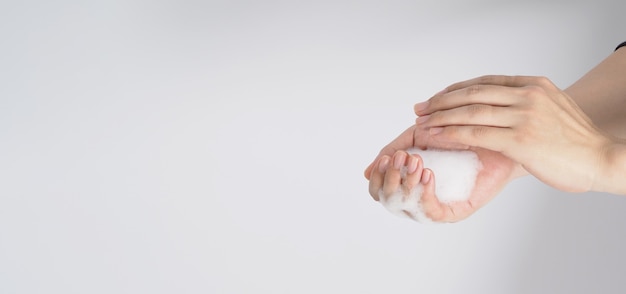 Фото Жест мытья рук и пенящееся мыло для рук в руке на белом фоне.