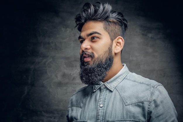 Photo a handsome bearded indian male dressed in a fleece shirt over grey vignette background.