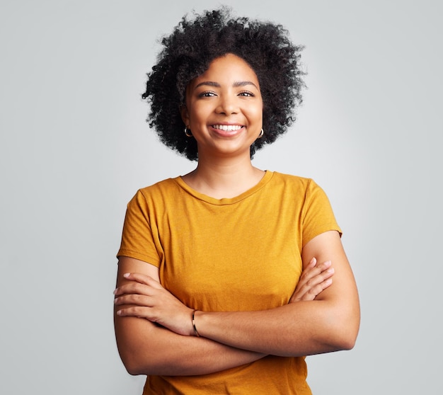 Photo happy woman and arms crossed for portrait in studio white background and backdrop young female model smile and natural curly afro hair with positive personality gen z and girl of south africa