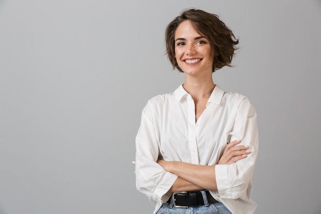 Photo happy young business woman posing isolated over grey wall