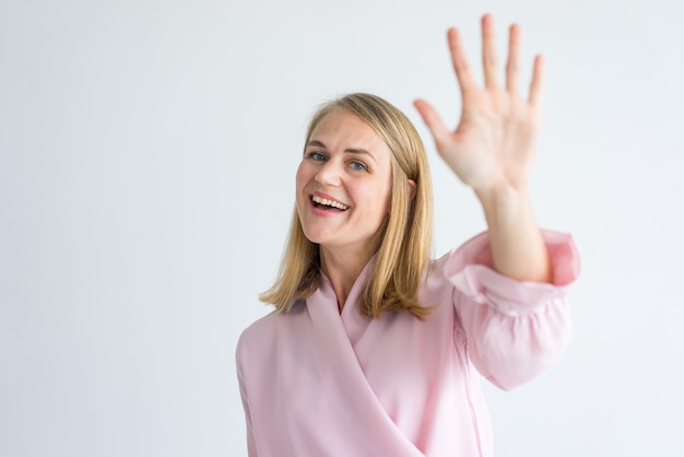 Photo happy young caucasian businesswoman wearing pink blouse waving hand in greeting