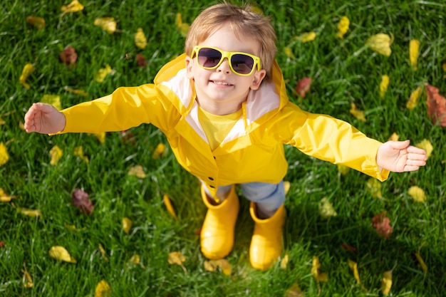 Фото Счастливый ребенок весело на открытом воздухе в осеннем парке