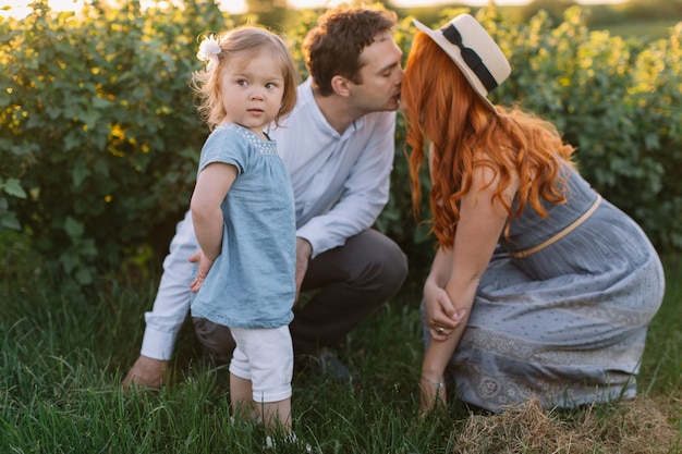 Фото Счастливая семья с маленькой дочерью, проводить время вместе в солнечном поле