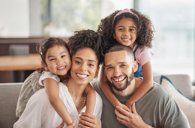 Photo happy smile and portrait of an interracial family sitting on a sofa in the living room at home happiness love and adoptive parents bonding embracing and relaxing with their children in the lounge