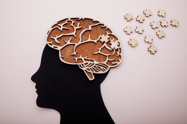 Photo head of man with brain and wooden puzzle. alzheimer's disease, dementia and mental health concept.