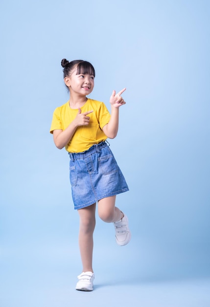 Photo image of asian child posing on blue background