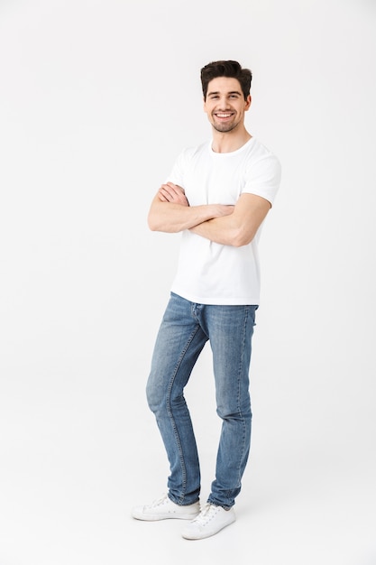 Image of a happy young excited emotional man posing isolated over white wall .