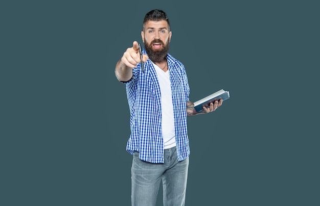 Photo indignant bearded man making notes in book on grey background