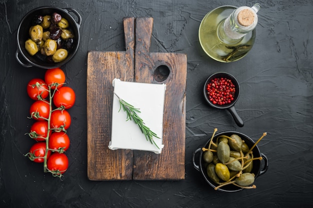 Ингредиенты для традиционного греческого салата, на черном столе, плоская планировка