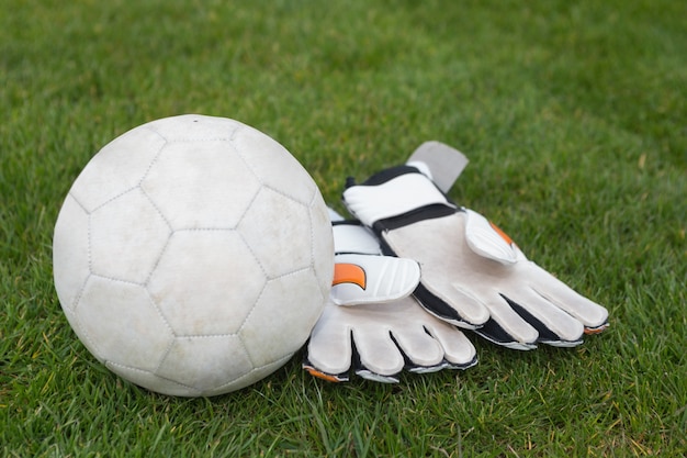 Foto keepershandschoenen en voetbal op het veld