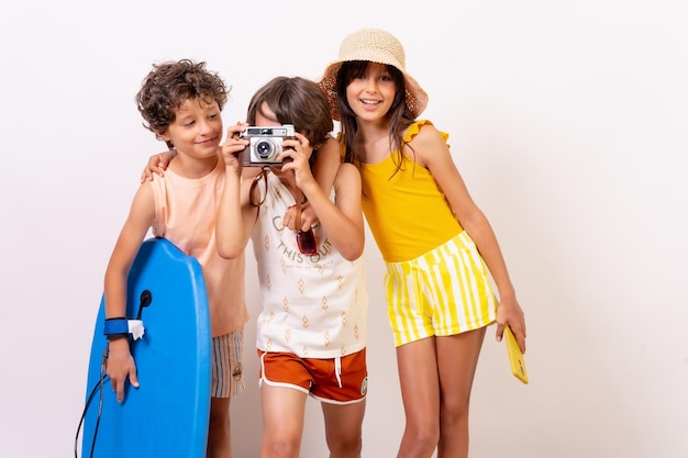 Kids summer vacation on a white background boy taking a photo with vintage camera looking at camera