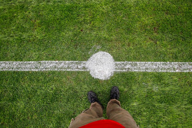 Foto sezione bassa di un uomo in piedi sul campo da calcio