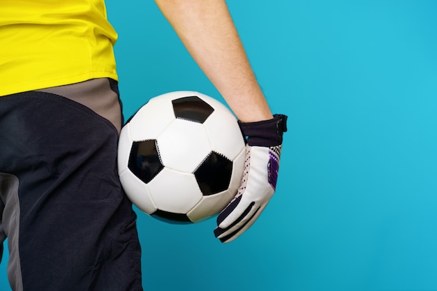 Фото Мужчина-болельщик в желтой футболке с футбольным мячом на синем фоне