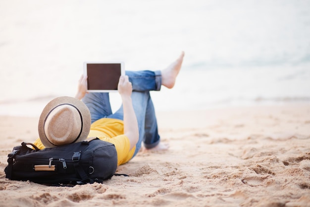 Фото Человек лежит на песке на пляже напротив неба