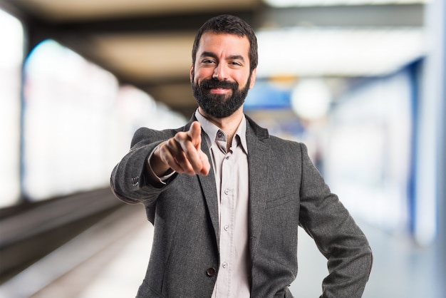 Man pointing to the front on unfocused background