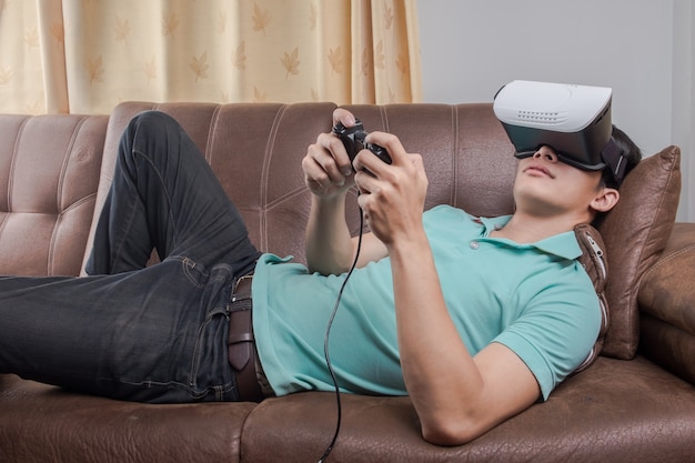 Photo man wearing virtual reality goggles watching movies or playing video games. the vr headset design is generic and no logos.