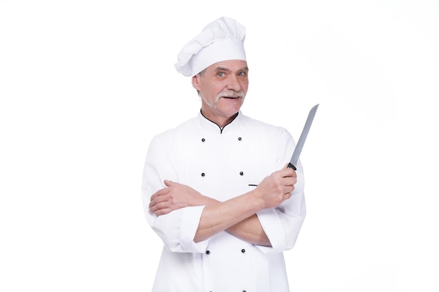 Шеф-повар-мужчина в униформе с металлическим ножом на белой стене