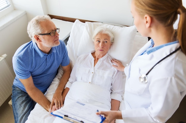 Фото Медицина, возраст, здравоохранение и концепция людей - пожилая женщина, мужчина и врач с буфером обмена в больничной палате