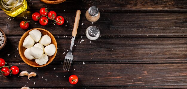 Фото Сыр моцарелла на тарелке на столе с помидорами и специями