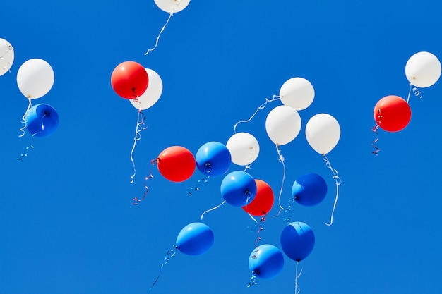 Фото Разноцветные гелиевые шары, взлетающие в голубое небо.