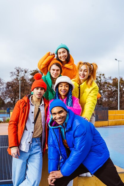 Фото Многорасовая группа молодых друзей, встречающихся зимой на открытом воздухе