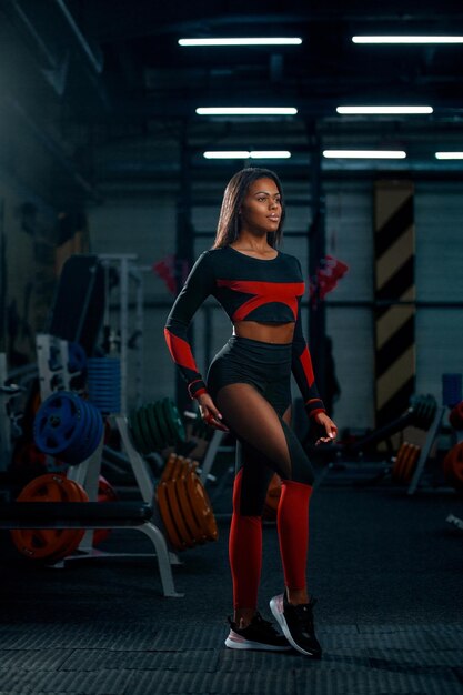 Фото Мышечная молодая фитнес-спортсменка тренируется с гантелью в фитнесси.