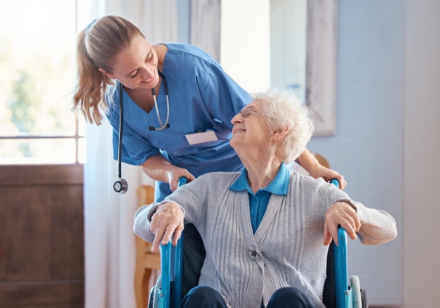 Photo nurse home and elderly woman with a disability in a wheelchair in medical nursing facility happy healthcare and doctor helping and talking to disabled senior lady in retirement house in australia