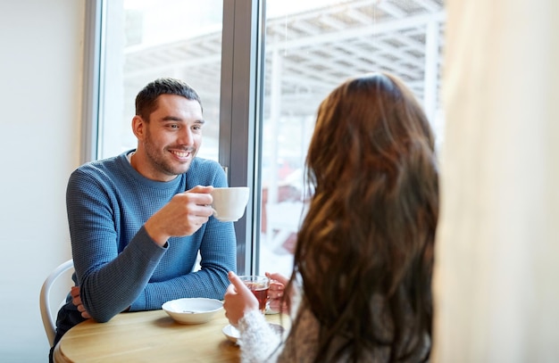 Фото Люди, общение и знакомства - счастливая пара пьет чай и кофе в кафе