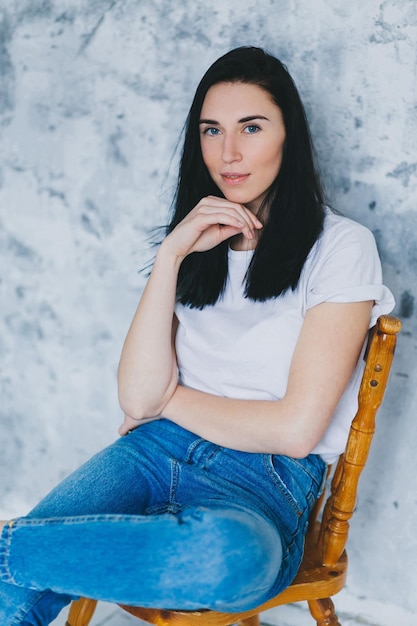 Photo portrait of woman sitting on chair against wall