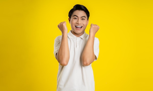 Photo portrait of young asian man posing on yellow background