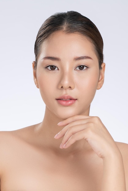 Portrait of gorgeous young girl posing beauty gesture with healthy clear skin and soft makeup Cosmetology and beauty concept