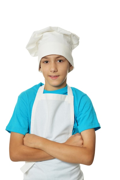 Portrait of little boy wearing chef uniform on white background