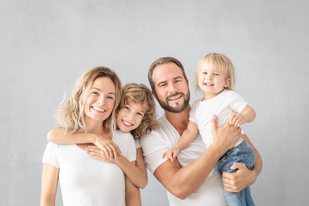 Фото Портрет счастливой семьи - отца, матери, дочери и сына - на серой поверхности