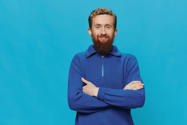 Фото Портрет рыжеволосого мужчины с бородой в свитере улыбка и знаки и символы руки счастья на синем фоне образ жизни положительное место для копирования