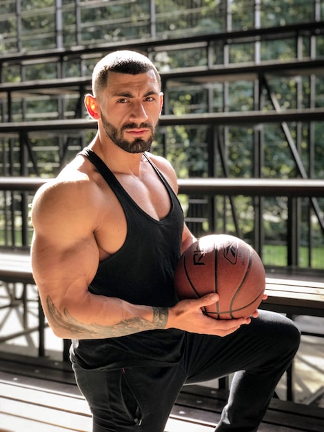 Фото Портрет мускулистого человека с баскетболом в руках