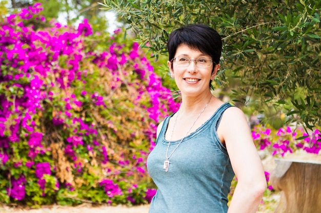 Фото Портрет улыбающейся женщины, стоящей на фиолетовых цветущих растениях