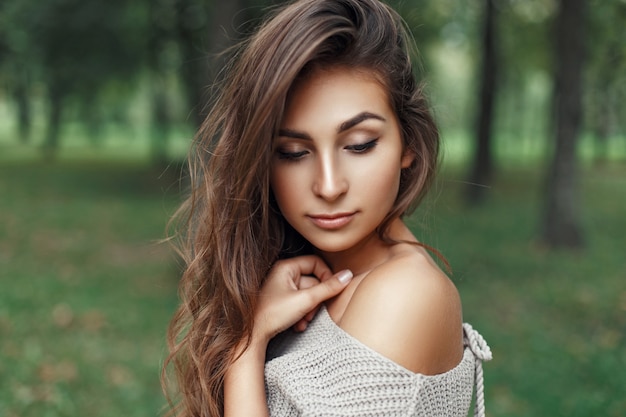 Photo pretty young girl with the hairstyle in vintage stylish sweater looks down