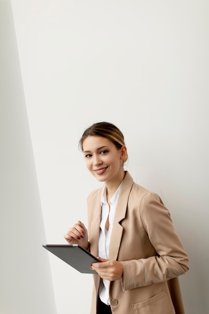 Фото Довольно молодая женщина, держащая цифровой планшет в современном офисе