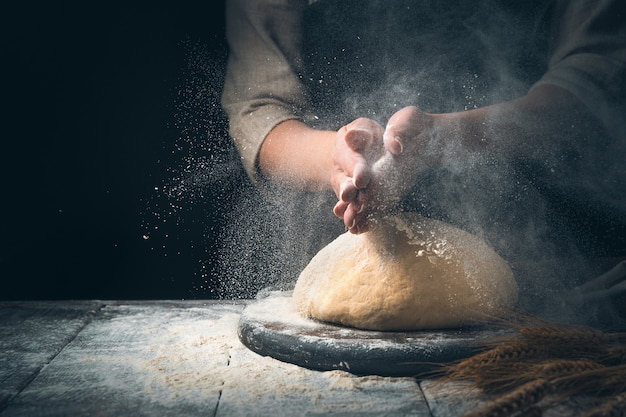 preparation of bread. Knead the dough in a cloud of dust from the flour.