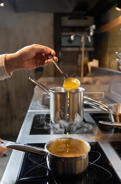 Рецепт тыквенного супа: рука шеф-повара кладет ингредиенты в кастрюлю и готовит все, что нужно для супа