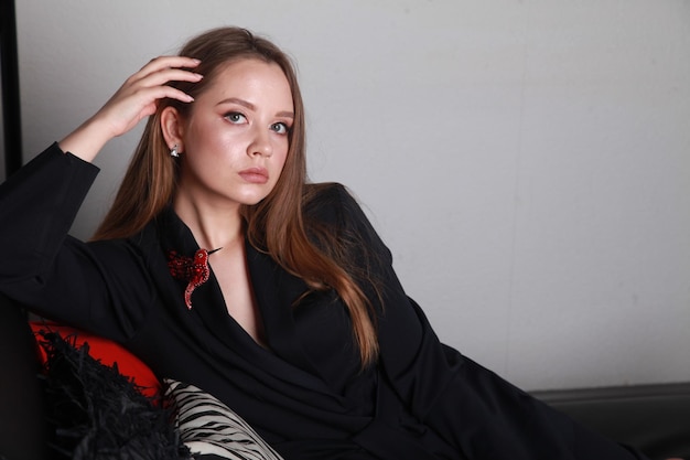 사진 검은 스마트워치 슈트 를 입은 러시아 의 패션 모델 이 긴 하루 후 소파 에 누워서 휴식을 취하고 있다