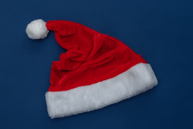 Photo santa hat on classic blue background. color 2020. christmas theme. top view