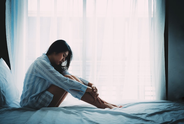 Photo sad and lonely asian woman in bedroom