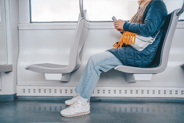 Старшая женщина отправляет сообщение с мобильного телефона в поезде