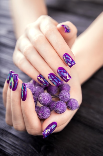 Photo shattered glass purple manicure on black background