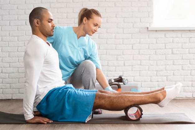 Фото Вид сбоку на человека и физиотерапевта, делающего упражнения
